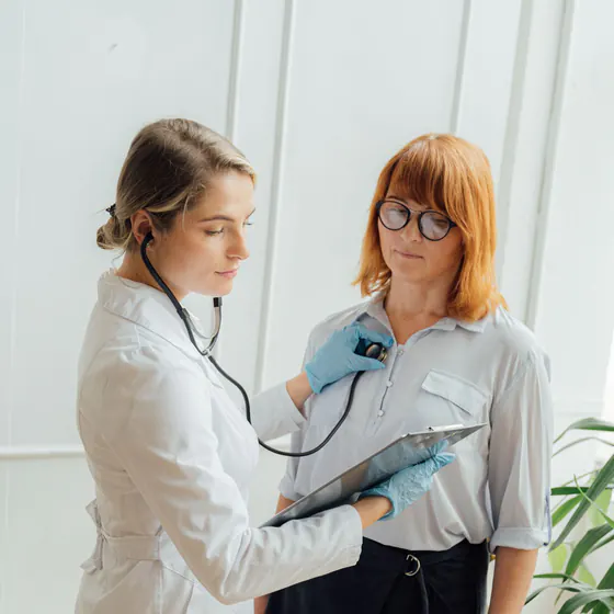 Médecin spécialiste mesurant la tension artérielle d'une patiente au stéthoscope